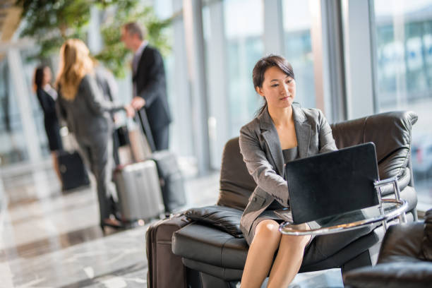 istock Businesswoman using laptop at airport 996734400