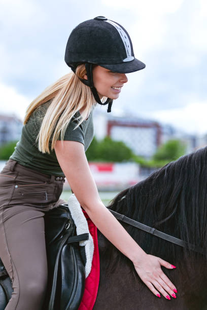 istock Smiling woman riding a horse 996741830