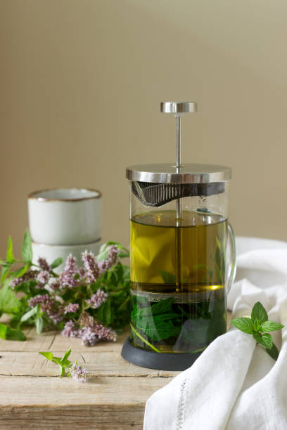 istock Mint tea in a clear glass teapot, mint leaves and tea cups. 996743624