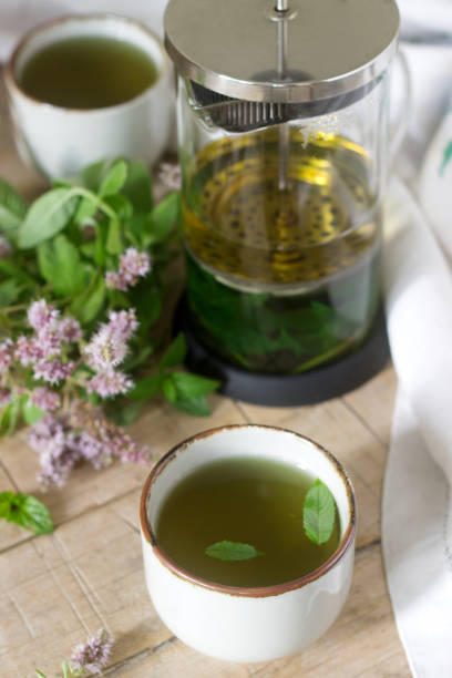 istock Mint tea in a clear glass teapot, mint leaves and tea cups. 996746032