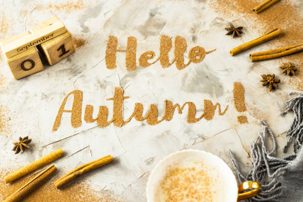 istock Hello, Autumn. The phrase is written with ground cinnamon on a gray background. Next to the wooden calendar on which the date is September 1. Top view, flat lay 996757226