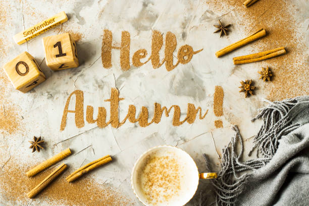 istock Hello, Autumn. The phrase is written with ground cinnamon on a gray background. Next to the wooden calendar on which the date is September 1. Top view, flat lay 996757242