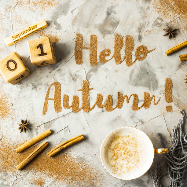 istock Hello, Autumn. The phrase is written with ground cinnamon on a gray background. Next to the wooden calendar on which the date is September 1. Top view, flat lay 996757280