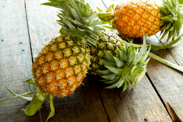 istock Pineapples eruit on wooden background 996758530