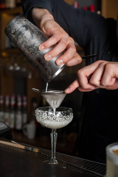 istock The bartender makes a cocktail of coconut and ice. Macro, black background, hand, white 996761850