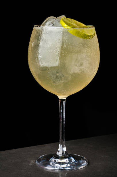 istock a bartender makes a summer cocktail of lime and ice. Macro, black background, hand, yellow, drops on glass, bubbles 996762486