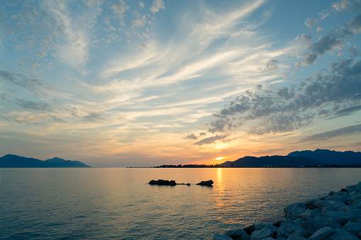 Inspirational beautiful mountains landscape with sea, coast, beach and rocks, mountains in background at sunset in Croatia.