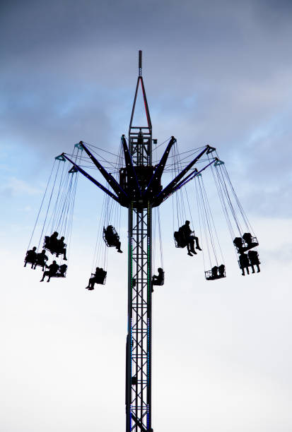 istock Silhouette of People on a Chain Swing Ride 996773826