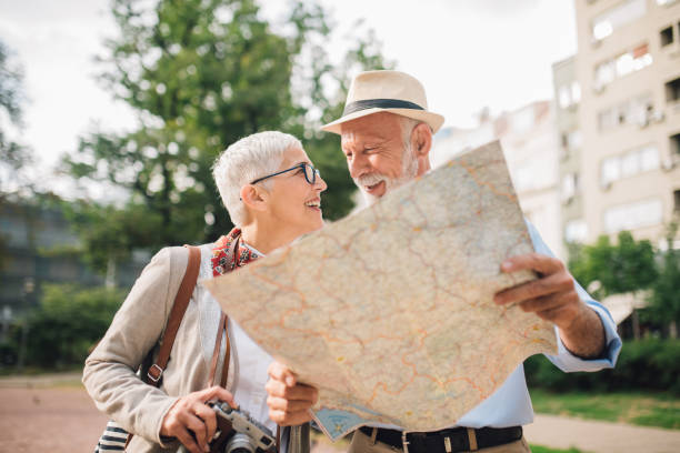 istock Elderly couple in love looking at each other while holding a map 996776008