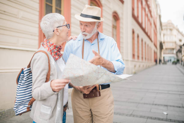 istock Senior man talking to woman holding touristic map 996776162
