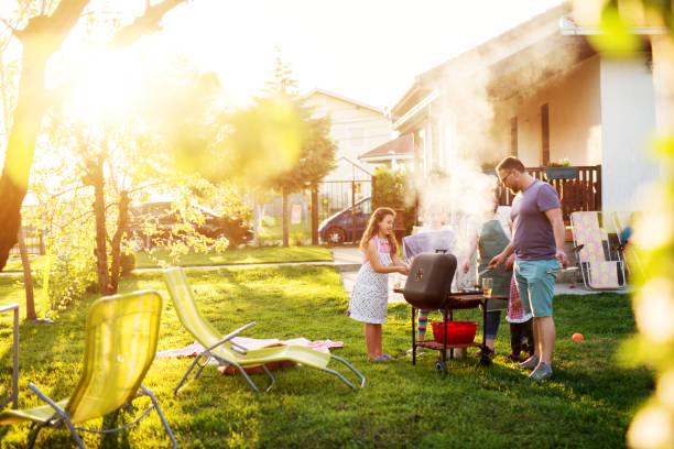 beautiful couple and their adorable children have gathered around the grill  in front of the house. - dutch ethnicity imagens e fotografias de stock