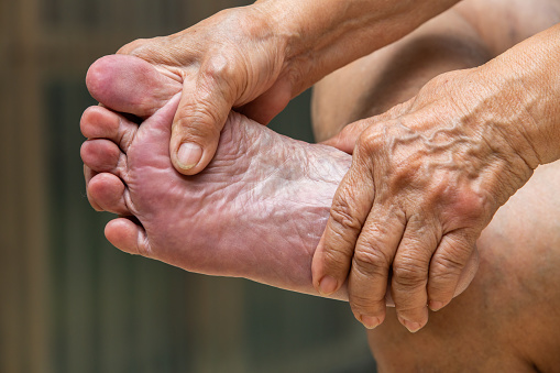 Masaje de manos de la mujer Senior dando masajes a su pie, sobre concepto photo