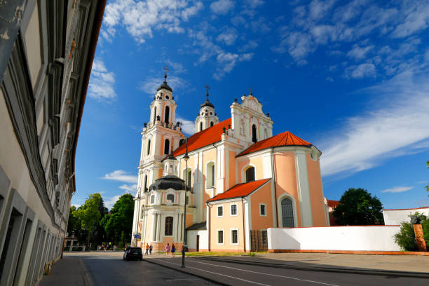Vilnius, Lithuania - June 16, 2018: Baroque and Rococo-style St. Catherine's Church in brilliant afternoon sun. A few people on the Vilniaus Gatvė. Picture taken with polarizing filter