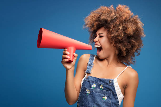 afro junges mädchen schreien durch rotes megaphon. - megaphone women at attention using voice stock-fotos und bilder