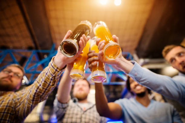 4 남자 친구 술집에 부딪치는 동안 초안 맥주 안경의 밑면 보기. - usa netherlands 뉴스 사진 이미지