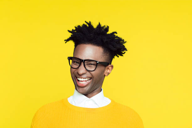 Yellow portrait of nerdy young man making funny face Funny portrait of nerdy young afro American man wearing yellow sweater laughing at the camera. cheesy grin photos stock pictures, royalty-free photos & images