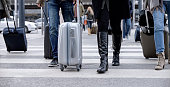 Business people walking with wheeled luggage