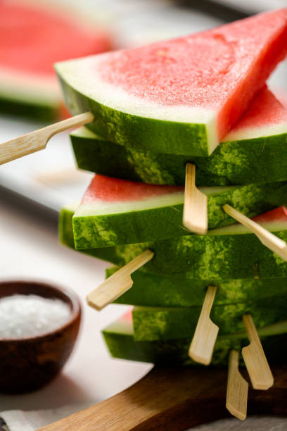 istock Sliced watermelon in triangle shapes on wooden sticks. 996800758