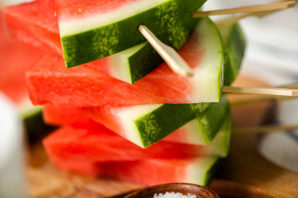 istock Sliced watermelon in triangle shapes on wooden sticks. 996800766