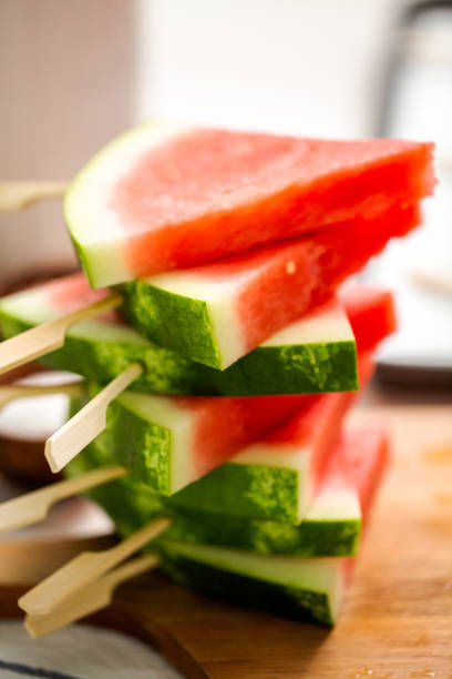 istock Sliced watermelon in triangle shapes on wooden sticks. 996800778