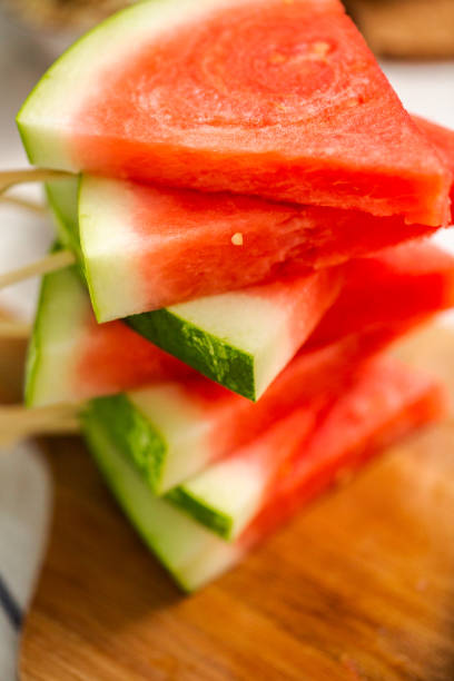 istock Sliced watermelon in triangle shapes on wooden sticks. 996800782