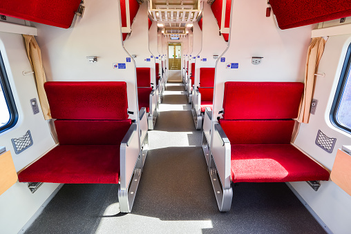 Perspective view of red seat in the train with light and shadow from the outside