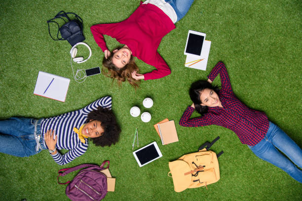 istock overhead view of smiling multicultural students lying on green lawn 996813440