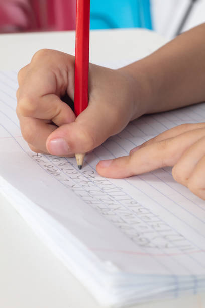 istock Children's hands holding pencil and doing homework 996822244