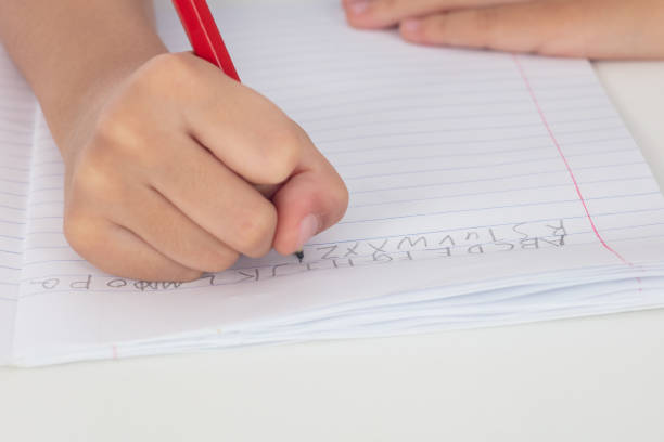istock Children's hands holding pencil and doing homework 996822282