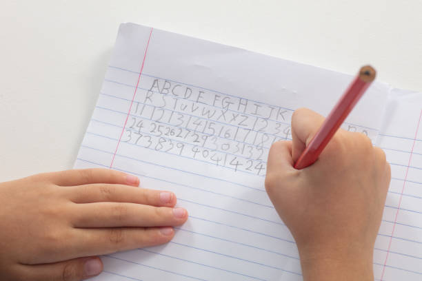 istock Children's hands holding pencil and doing homework 996822300