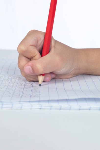 istock Children's hands holding pencil and doing homework 996822356