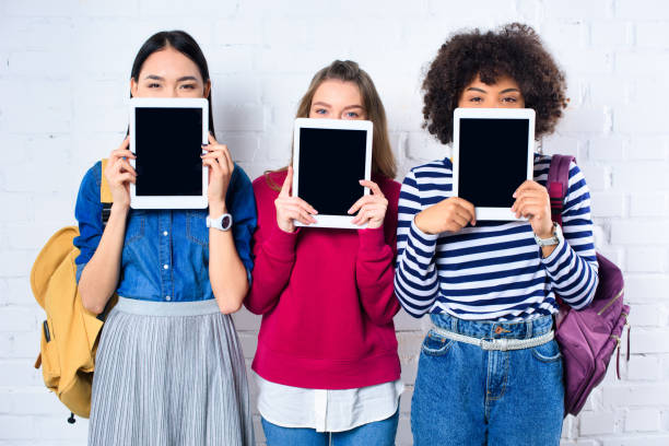 istock obscured view of multiethnic students showing tablets with blank screens in hands 996824918