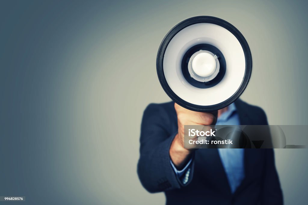 businessman with megaphone in hand in front of face Megaphone Stock Photo