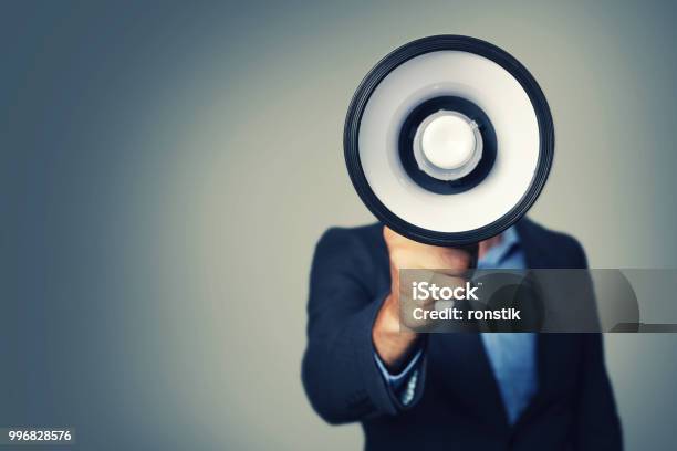 Businessman With Megaphone In Hand In Front Of Face Stock Photo - Download Image Now