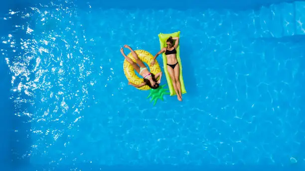 Single mother with her daughter spending time in the pool.