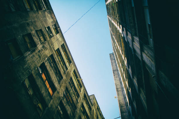 Low angle view of an old, aged and musty dilapidated abandoned building occupied by social housing movement.