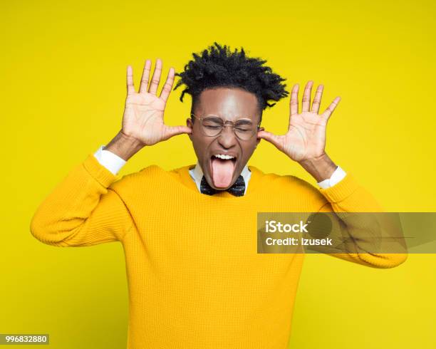 Funny Portrait Of Nerdy Young Man Sticking Out Tongue Stock Photo - Download Image Now
