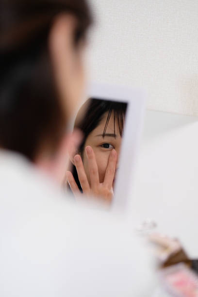 istock woman putting concealer on face 996835728