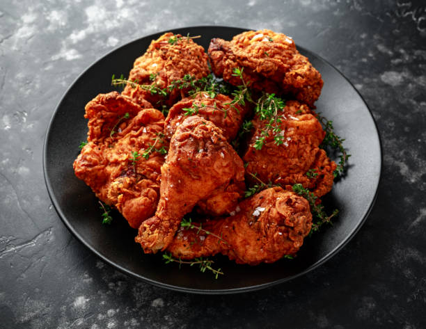 istock Fried crispy chicken legs, Thigh in a black plate with herbs 996839128
