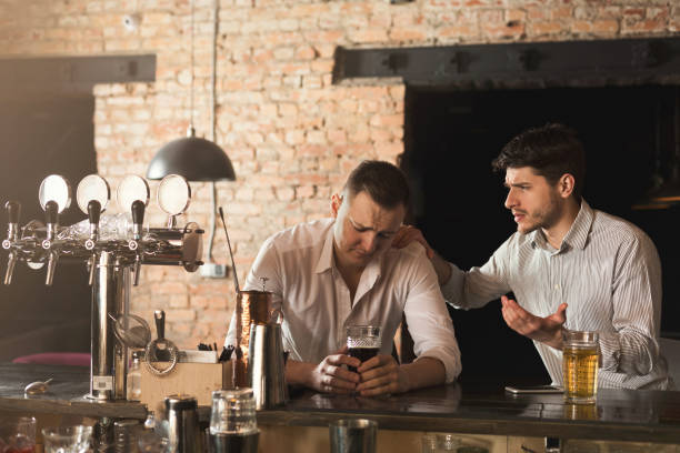 istock Consoling his depressed friend at bar 996842538