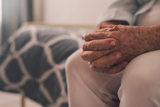 The wait is long Cropped shot of a senior woman sitting with her hands clasped in a retirement home old hands stock pictures, royalty-free photos & images