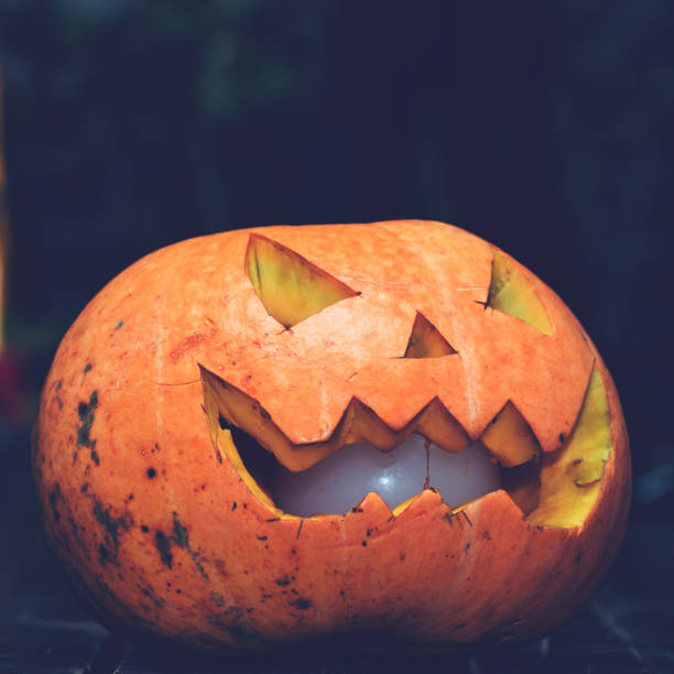 istock close-up Halloween pumpkin head jack lantern on dark wooden back 996847620