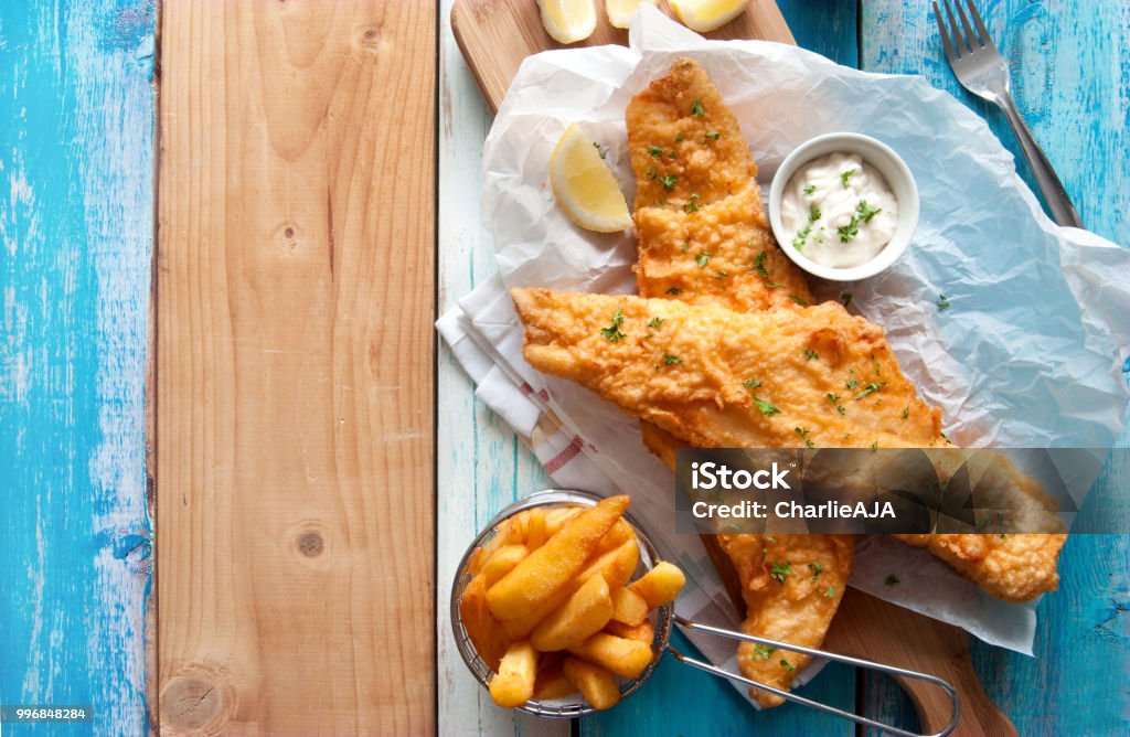 Rustic fish and chips Traditional British fried fish in batter with chips in a basket Fish Stock Photo