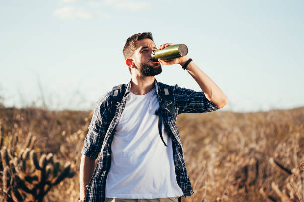 istock Man taking a break to drink from water bottle while hiking at Brazilian Caatinga 996860522