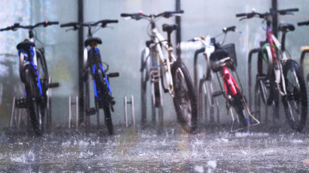 istock Parked public bicycle rental stand on the asphalt in the pouring deep rain 996872016