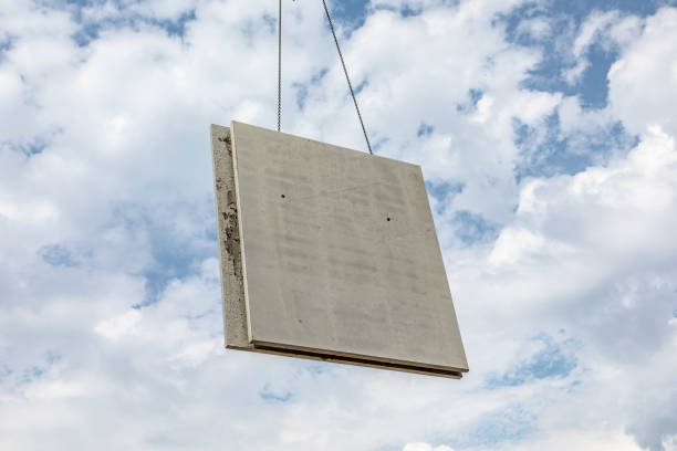 istock prefabricated wall is placed at the construction site with help of a huge crane 996876698