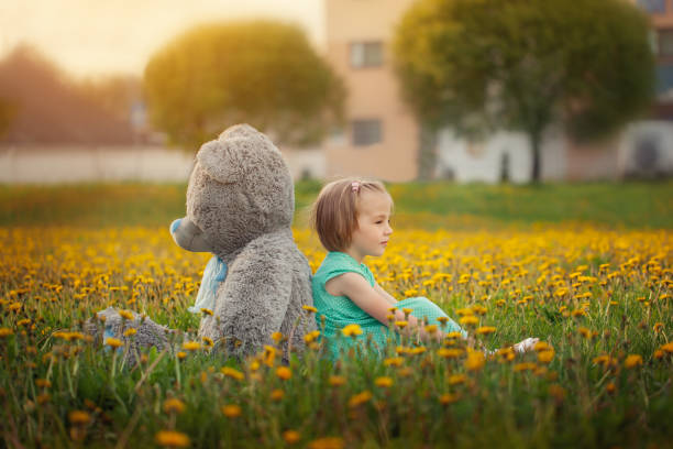 istock Cute little girl playing with big bear in summer 996883254