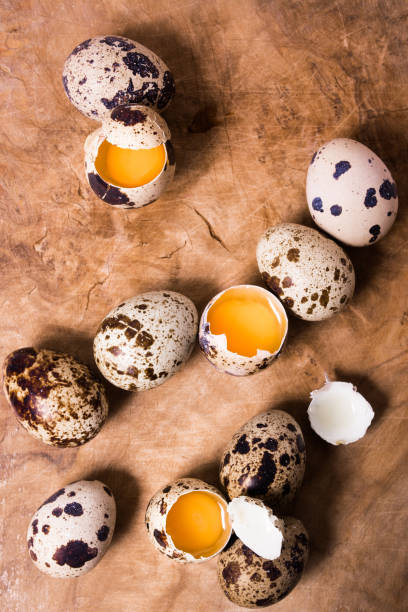 Raw quail eggs on the wooden background Raw quail eggs on the wooden background with some open eggs proteína stock pictures, royalty-free photos & images