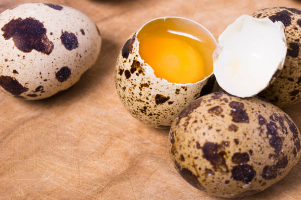 Raw quail eggs on the wooden background Raw quail eggs on the wooden background with some open eggs proteína stock pictures, royalty-free photos & images