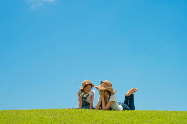 istock Mother and daughter relaxing in the meadow 996886854